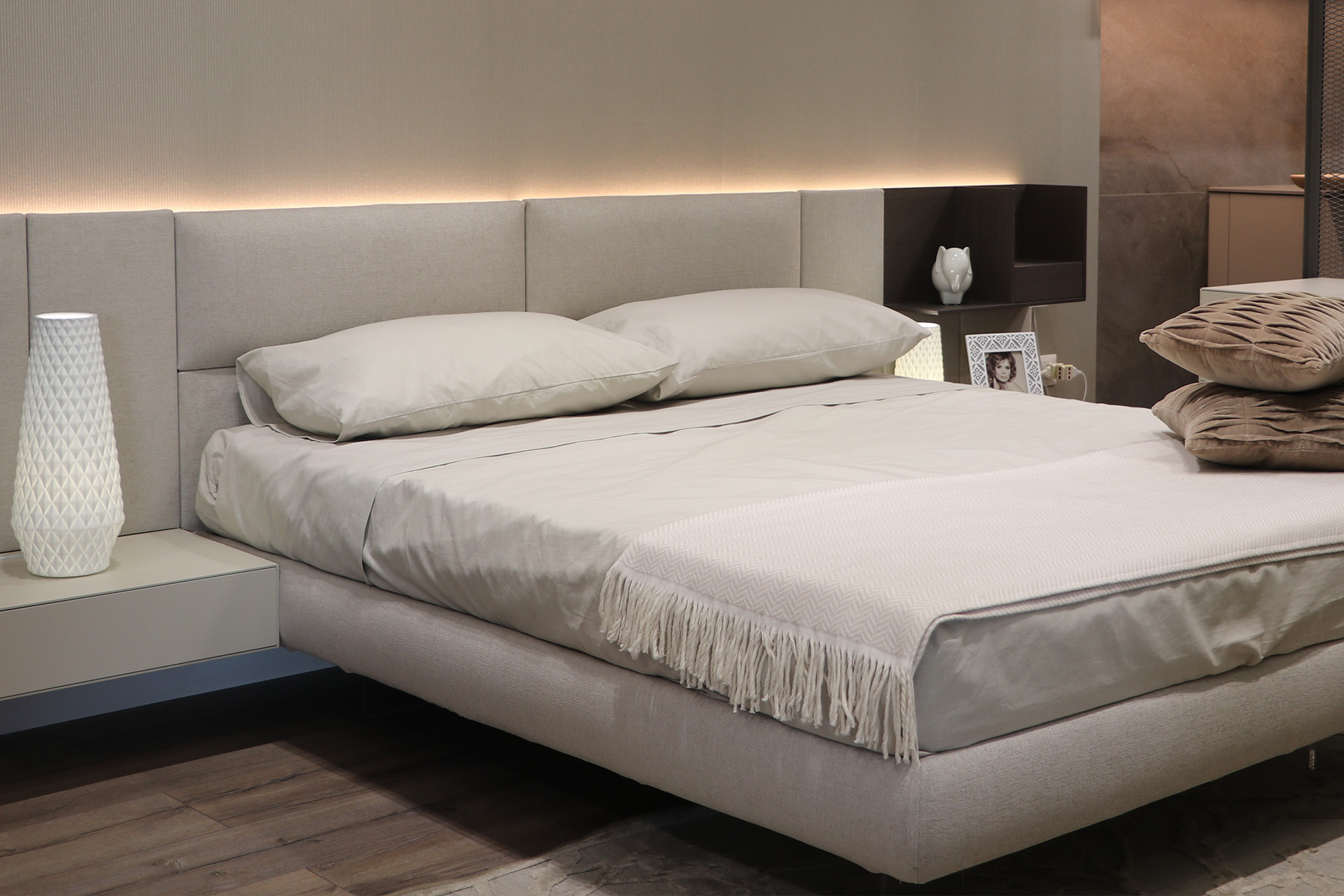 Showroom zona notte con un letto bianco visto in prospettiva situato in una stanza da letto